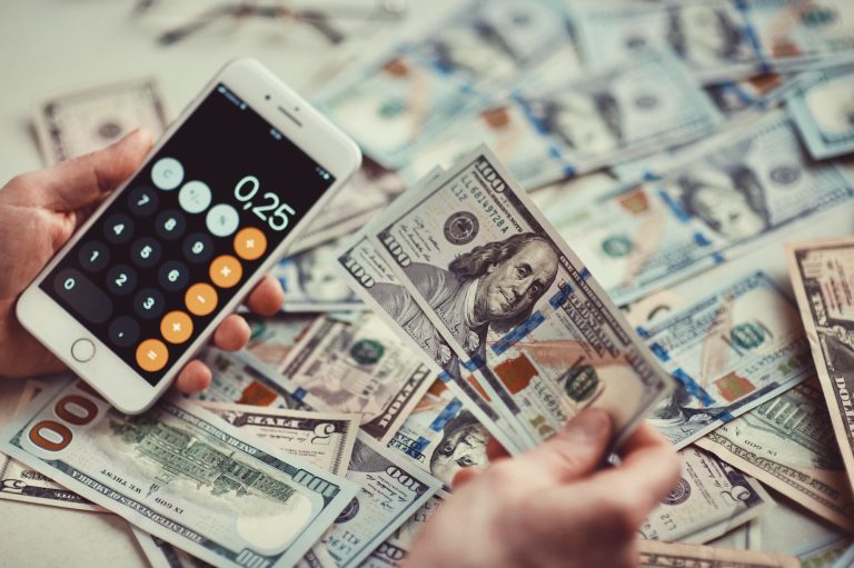 An image of cash and a calculator. Calculate how much you would save with a credit card consolidation loan.